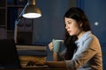 Asian business woman drink coffee refreshing working overtime la Royalty Free Stock Photo