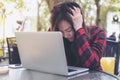 Asian business woman with feeling stressed and tired , close her eyes while using laptop on glass table sitting at outdoor with gr Royalty Free Stock Photo