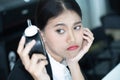 Asian business woman feeling tired and bored waiting for someone coming late at work