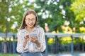 Asian business woman happy smiling looking at smartphone standing park outdoor green nature background Royalty Free Stock Photo