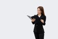 Asian business woman holding and reading document in folder in black suit isolated on white color background Royalty Free Stock Photo