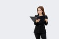 Asian business woman holding and reading document in folder in black suit isolated on white color background Royalty Free Stock Photo