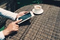 Asian business woman holding and using smart phone with black blank empty screen at cafeteria Royalty Free Stock Photo