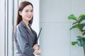 Asian business woman holds document file in her hands and smiles happily in workplace Royalty Free Stock Photo