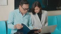 Asian business woman and man sitting using laptop computer working talking explain together on the subway train Royalty Free Stock Photo