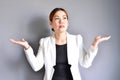 Asian business woman raising her hands on both sides on gray background. Royalty Free Stock Photo