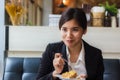 Asian business woman in relax time and eating apple pie in coffee shop. Royalty Free Stock Photo