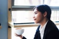 Asian business woman relaxing in coffee shop with hot coffee. Royalty Free Stock Photo