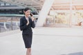 Asian business woman smile and hold cell phone to talk about bus Royalty Free Stock Photo