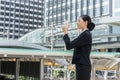 Asian business woman standing and drinking pure mineral water from plastic bottle Royalty Free Stock Photo