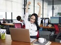 Asian business woman stretching arms in office