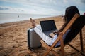 Asian business woman with tablet computer during tropical beach vacation. Freelancer working on laptop lying on sun lounger. Royalty Free Stock Photo