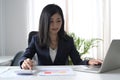 Business woman using calculator and working with laptop at office desk. Royalty Free Stock Photo