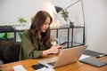 Asian business woman using laptop checking smartphone indoors home office Royalty Free Stock Photo