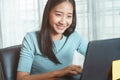 Asian business woman using laptop at office, Asian girl sitting smiling while working on mobile office concept Royalty Free Stock Photo