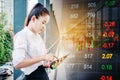 Asian business woman Using smartphone on digital stock market financial background