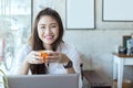 Asian Business woman wearing white shirt smile and holding coffee in Coffee shop cafe with computer laptop Royalty Free Stock Photo