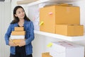 Asian business woman work at home office checking order ready to mailing or shipping with boxes and sticky note paper Royalty Free Stock Photo