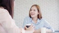 Asian business women enjoying drinking warm coffee, discuss about work and chit chat gossip while relax working in office. Smart Royalty Free Stock Photo