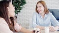 Asian business women enjoying drinking warm coffee, discuss about work and chit chat gossip while relax working in office. Smart Royalty Free Stock Photo