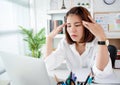Asian business women have stress and headaches from their work at the office