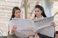 Asian business women reading newspaper together Royalty Free Stock Photo