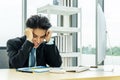 Asian Businessman being depressed by working on the laptop computer in office.Strain,Young business man to think and not Work with Royalty Free Stock Photo