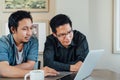 Asian businessman or business partner discussing project together using laptop computer at coffee shop. Team meeting or teamwork Royalty Free Stock Photo