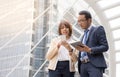 Asian businessman and businesswoman discussing ideas with using digital tablet and mobile phone Royalty Free Stock Photo