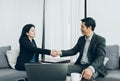 Asian businessman and businesswoman sitting at sofa handshake de Royalty Free Stock Photo