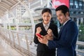 Asian businessman and businesswoman smile and looking mobile phone, cheerful and celebrated his successful in mission Royalty Free Stock Photo