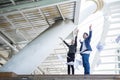 Asian businessman and businesswoman throwing paper in the air and raising up two hands to celebrated for successful in mission Royalty Free Stock Photo