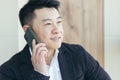 Asian businessman close-up portrait, successful and happy smiling talking on the phone, in a business suit Royalty Free Stock Photo