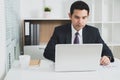 Asian businessman concentrating on using laptop computer Royalty Free Stock Photo