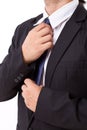 Asian businessman fastening his necktie