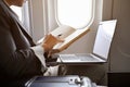 Asian businessman is on the flight, checking or writing something on notebook. cropped Royalty Free Stock Photo