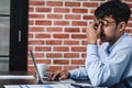 Asian businessman get stress and headache when working with laptop on desk at modern office.business fail concept.man caught eye Royalty Free Stock Photo