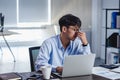 Asian businessman get stress and headache when working with laptop on desk at modern office.business fail concept.man caught eye Royalty Free Stock Photo