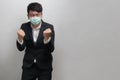 Asian businessman wearing surgical face mask in formal black suit jacket, felling happy, sucessful, studio lighting