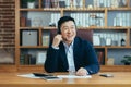 Asian businessman happy talking on video call in classic office, working at desk, using headset, online conference meeting Royalty Free Stock Photo