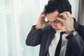 Asian businessman has headache from migraine from overworked. Il