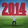 Asian businessman lifting new year 2014 Royalty Free Stock Photo