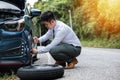 Businessman changing a flat tire