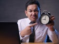 Asian Businessman Pointing at Clock, Angry Expression