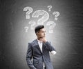 Asian businessman, question marks, chalkboard Royalty Free Stock Photo