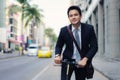 Asian businessman riding an electric scooter on the city streets to go to work in the morning. Daily commute that best reflect the Royalty Free Stock Photo