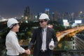 Asian businessman shake hand with engineer architect professional wearing safety helmet and holding construction roll plan for Royalty Free Stock Photo