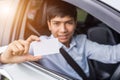 Asian businessman sitting in the modern car and holding blank of Royalty Free Stock Photo