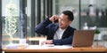 Asian businessman sitting on the phone with a customer with a laptop and document at his office desk. Royalty Free Stock Photo