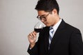 Asian businessman smell aroma of red wine